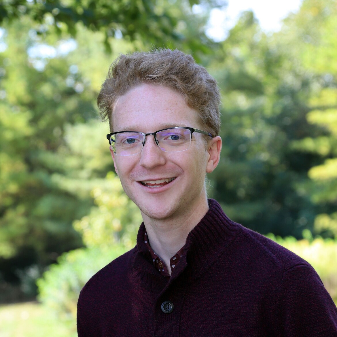 Alexander L. Hayes wearing glasses and a sweater